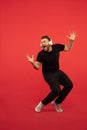 Full length portrait of young successfull high jumping man gesturing isolated on red studio background Royalty Free Stock Photo