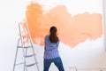 Dancing funny woman with painting roller indoors. Redecoration, renovation, apartment repair and refreshment concept. Royalty Free Stock Photo