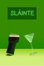 Dancing glasses modern concept. A pint of black stout beer glass and martini glass with green cocktail in front. Irish gaelic Royalty Free Stock Photo