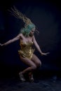 Dancing, Latin woman with green hair and gold costume with handmade flourishes, fantasy image and tale Royalty Free Stock Photo