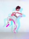 Dancing mixed race young girl in colourful neon studio light. Female dancer performer jumping hip hop dance Royalty Free Stock Photo