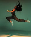 Dancing mixed race young girl jumping with waving hairs. Female dancer performer show expressive hip hop dance Royalty Free Stock Photo