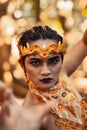 Dancing pose from a scary Balinese man with a golden necklace and crown on her body shirtless