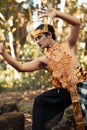 Dancing pose from a scary Balinese man with a golden necklace and crown on her body shirtless