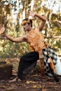 Dancing pose from a scary Balinese man with a golden necklace and crown on her body shirtless