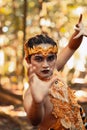 Dancing pose from a scary Balinese man with a golden necklace and crown on her body shirtless