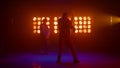 Dancing team silhouette performing modern movements in nightclub backlight. Royalty Free Stock Photo