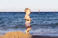 Dancing toddler boy on the beach aganst sea view