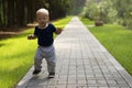 Dancing toddler in the park. First independent steps of cute one year baby boy