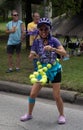 Dancing Woman with Tennis Ball Hula Hoop Wearing Purple and Turquoise at the 2023 Houston Art Car Parade