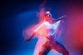 Dancing young mixed race girl enjoying moving in colorful neon studio light. Long exposure. Ethnic fiery dance Royalty Free Stock Photo