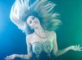 Dancing young woman over green and blue lights Royalty Free Stock Photo