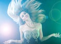 Dancing young woman over green and blue lights Royalty Free Stock Photo