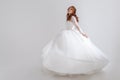 Dancing young woman in wedding dress. Charming bride on Light background. Royalty Free Stock Photo