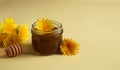 Dandelion flower jam in a glass jar on a beige background