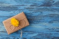 Dandelion flowers and gift box on wooden background