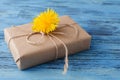 Dandelion flowers and gift box on wooden background