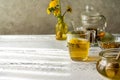 Dandelion honey and tea on the white wooden table with tea pot, dandelion flowers, dry herbal mix for infusion Royalty Free Stock Photo