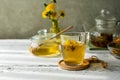 Dandelion honey and tea on the white wooden table with tea pot, dandelion flowers, dry herbal mix for infusion Royalty Free Stock Photo