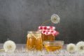 Dandelion jam, honey, jelly in a glass jar on a wooden table, black background with fresh flowers, dandelion airy seed Royalty Free Stock Photo