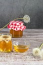 Dandelion jam, honey, jelly in a glass jar on a wooden table, black background with fresh flowers, dandelion airy seed Royalty Free Stock Photo