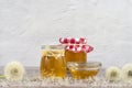 Dandelion jam, honey, jelly in a glass jar on a wooden table, white background with fresh flowers, dandelion airy seed Royalty Free Stock Photo