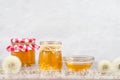 Dandelion jam, honey, jelly in a glass jar on a wooden table, white background with fresh flowers, dandelion airy seed Royalty Free Stock Photo