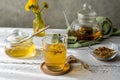 Dandelion tea and honey on the white wooden table with tea pot, dandelion flowers, dry mix for tea Royalty Free Stock Photo