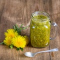 Dandelion yellow flower tea drink in glass mug on wooden table. Concept of healthy eating, herbal flower tincture Royalty Free Stock Photo