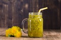 Dandelion yellow flower tea drink in glass mug on wooden table. Concept of healthy eating, herbal flower tincture Royalty Free Stock Photo