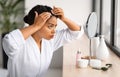 Dandruff Problem. Upset Black Woman Looking To Mirror At Her Hair Roots Royalty Free Stock Photo