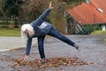 Danger in autumn. A woman slips on a road on wet leaves