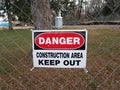 Danger construction area keep out sign on fence with outhouse Royalty Free Stock Photo