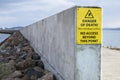 Danger of death no access beyond this point sign at harbour wall