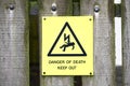 Danger of death sign on wooden fence