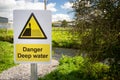 Danger Deep Water warning sign close up by rural waterway river stream. Beware falling in, drowning. Royalty Free Stock Photo