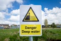 Danger Deep Water warning sign close up by rural waterway river stream. Risk of falling in, drowning Royalty Free Stock Photo