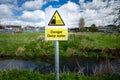 Danger Deep Water warning sign on rural river bank. Risk of falling in and drowning. Slip hazard.