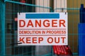 Danger Demolition in Progress Keep Out sign on metal construction fence