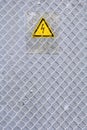 Danger of electrocution yellow sign on gray. High voltage warning sign Royalty Free Stock Photo