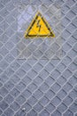 Danger of electrocution yellow sign on gray. High voltage warning sign Royalty Free Stock Photo