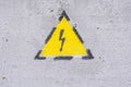 Danger of electrocution yellow sign on painted wall. High voltage warning sign Royalty Free Stock Photo