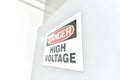 Danger High Voltage signs taped to a door before entering a high voltage room.
