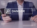 DANGER inscription on the screen. Close up Businessman hands holding black smart phone Royalty Free Stock Photo