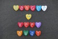 Danger, keep away, text with colored heart stones over black volcanic sand