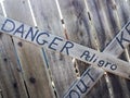 Danger keep out peligro sign painted on wood fence