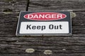 Danger, keep out warning sign over old weathered rustic wooden t Royalty Free Stock Photo
