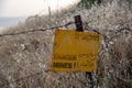 Danger mines - yellow warning sign next to a mine field, close to the border with Syria, in the Golan Heights, Israel Royalty Free Stock Photo