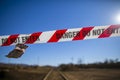 Danger red and white tape barricade exclusion zone area with written authorised personnel entry only on train track Royalty Free Stock Photo