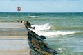 Danger, restricted area, keep off sign. Bright red and white public warning sign at a rocky coastline. Swimming restriction area.